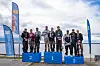 Team Blyskalle står samlat på prispallen med förstaplatsen i mitten vid en sjö.